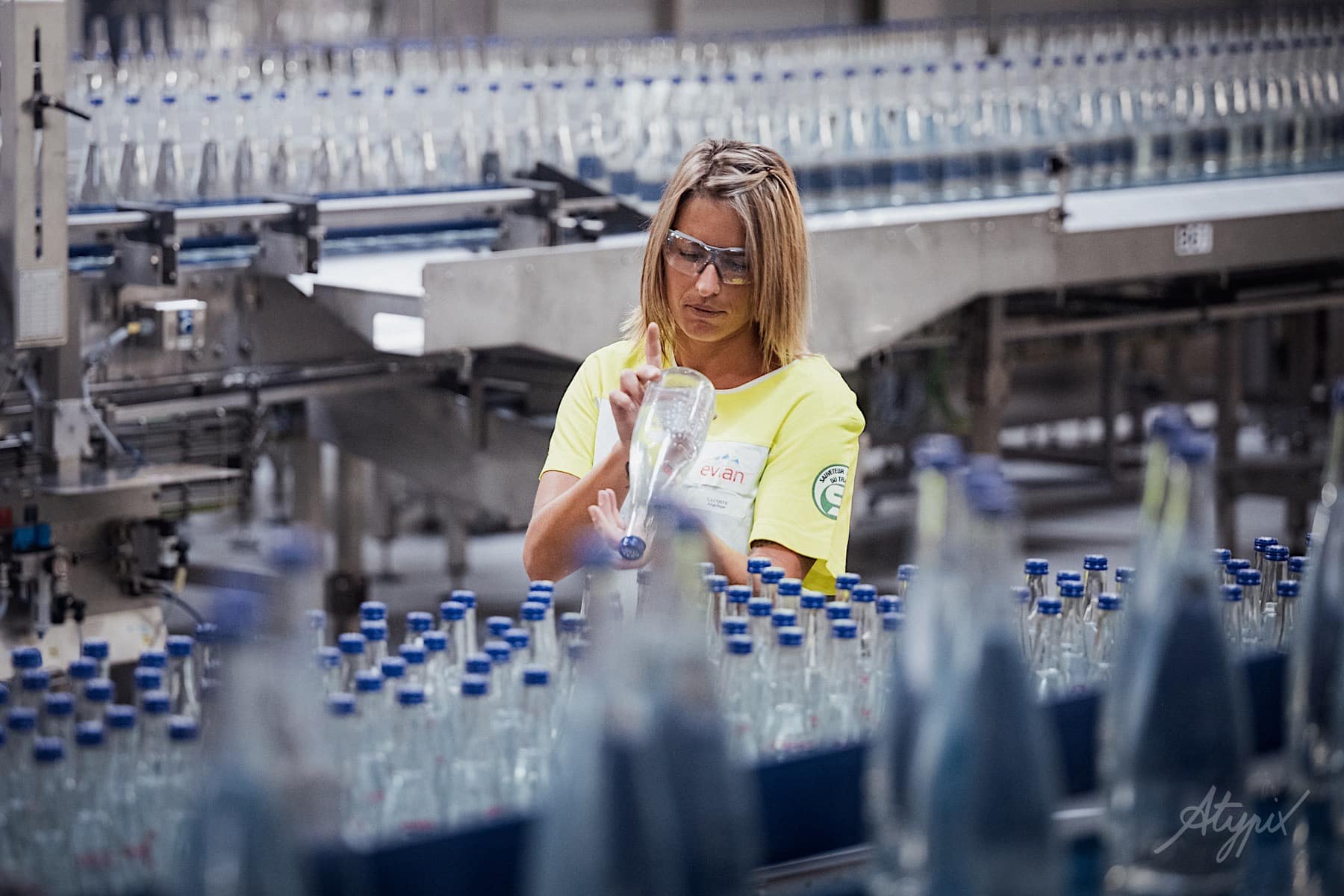 photo d'une femme sur une ligne de production de bouteilles d'eau