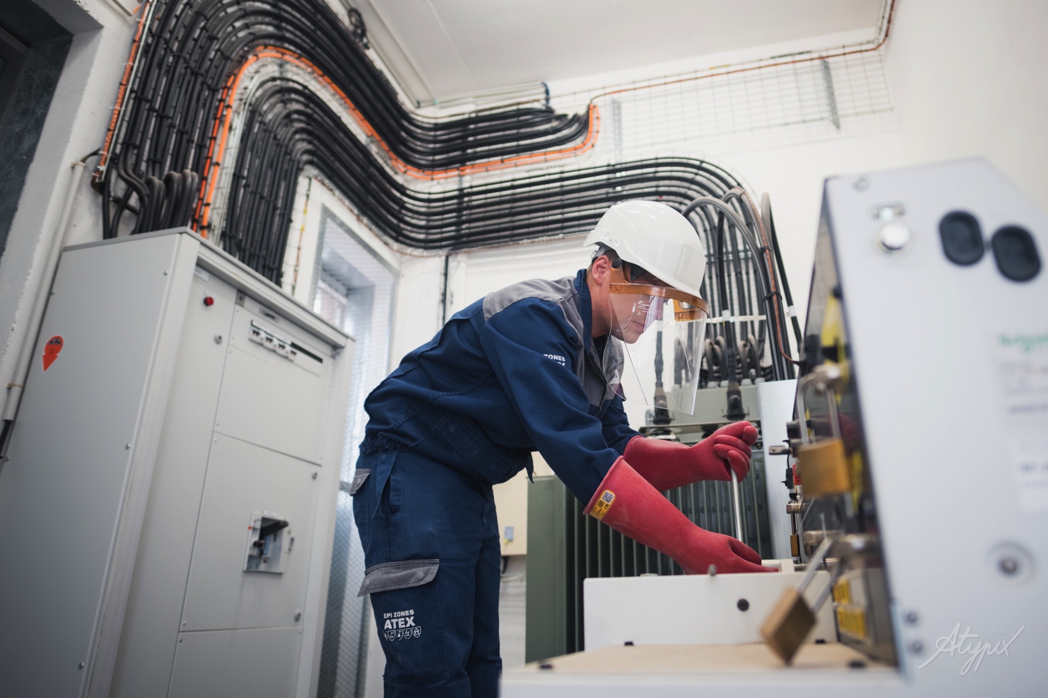Technicien intervenant sur une installation électrique industrielle avec équipements de protection adaptés