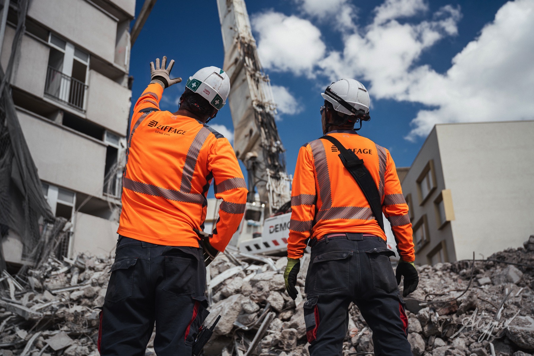Deux collaborateurs Demcy observant l’intervention de la pelle de démolition à Nanterre.