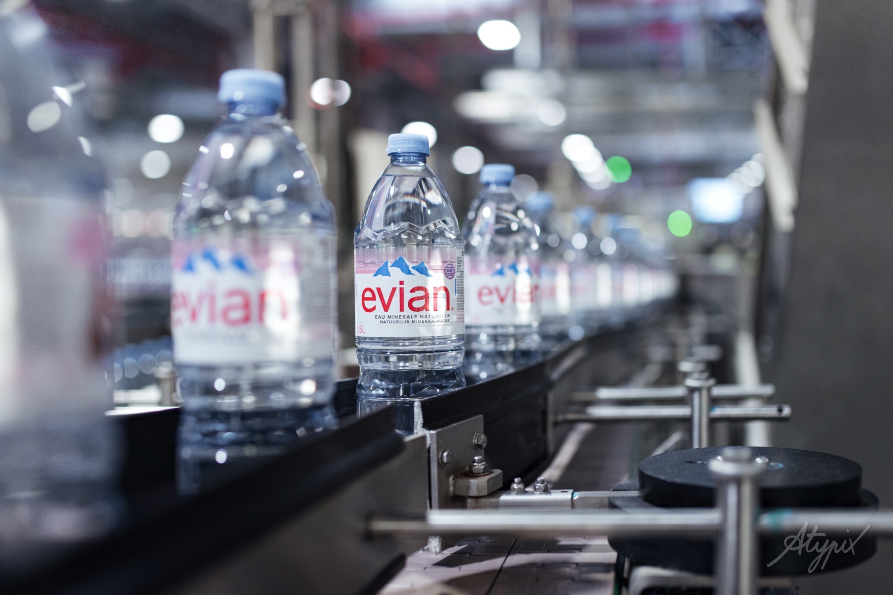 Bouteilles Evian transportées sur une ligne de conditionnement automatisée.