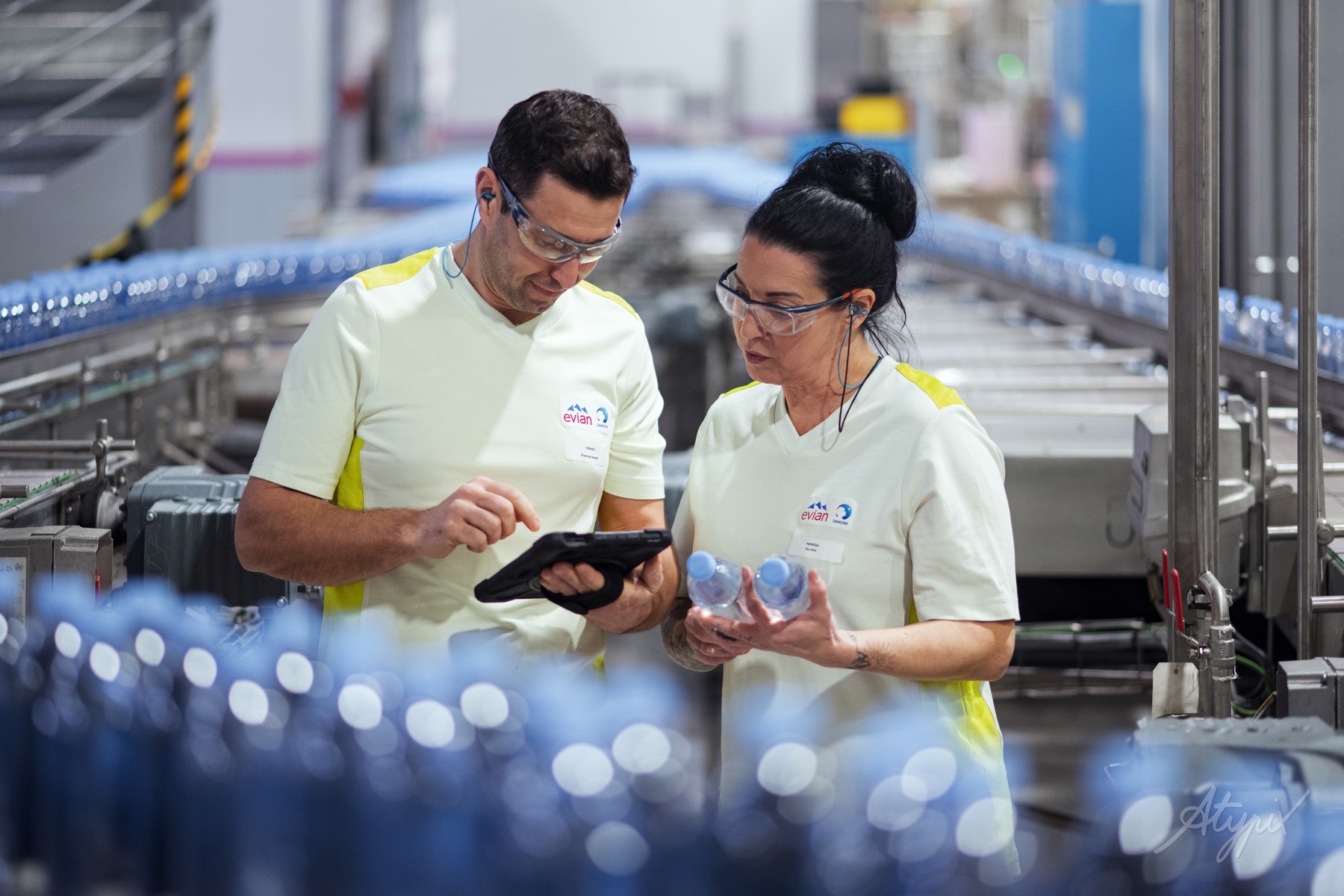 evian-controle-qualite-bouteilles-equipe Deux collaborateurs réalisant un contrôle qualité sur des bouteilles Evian en production.