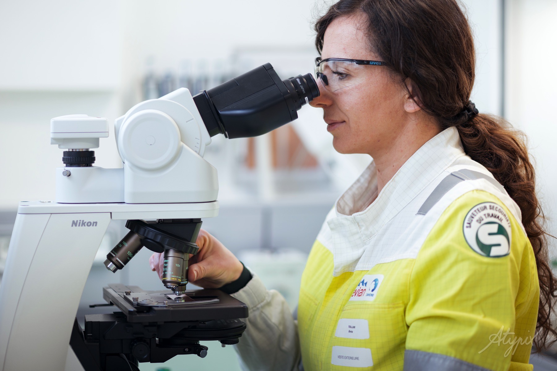 evian-controle-qualite-microscope Collaboratrice Evian réalisant une observation au microscope dans le laboratoire qualité.