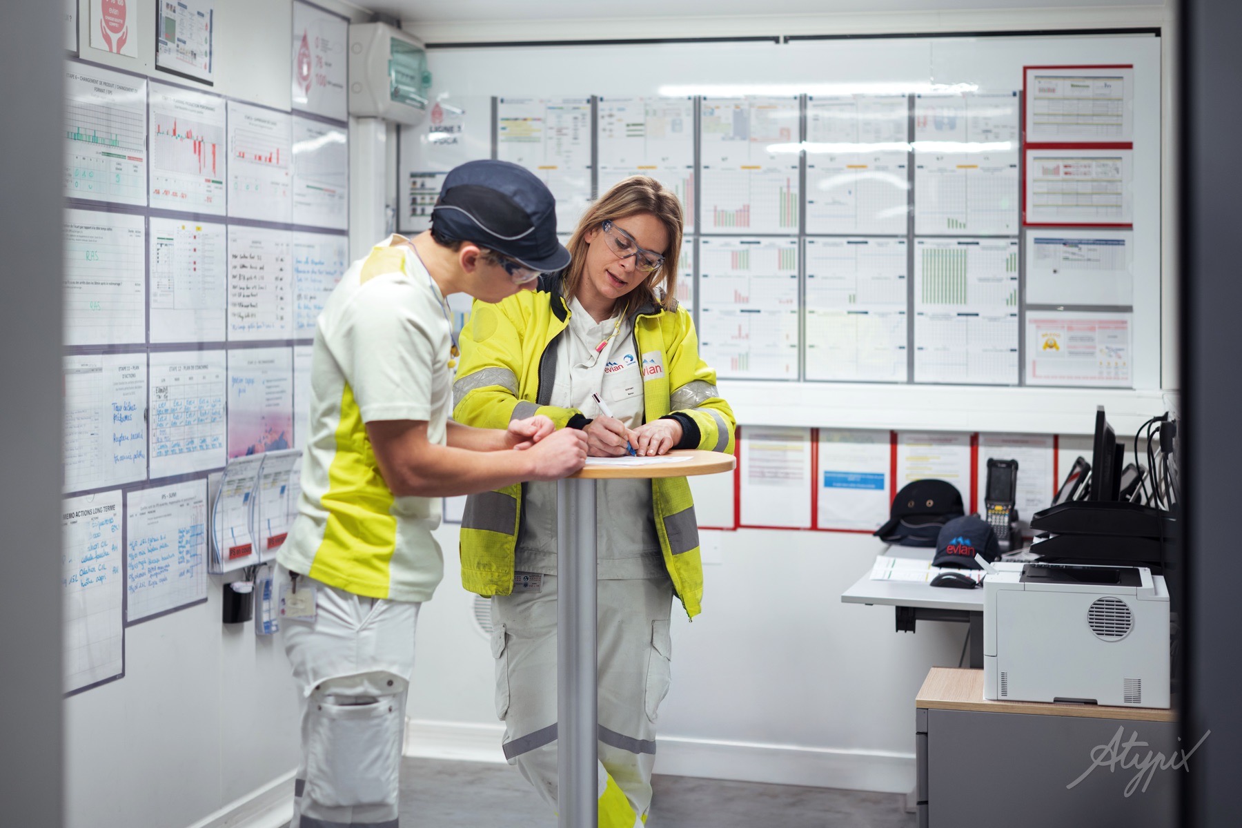 evian-equipe-production-tablette Deux collaborateurs Evian consultant une tablette dans un espace de pilotage de la production.